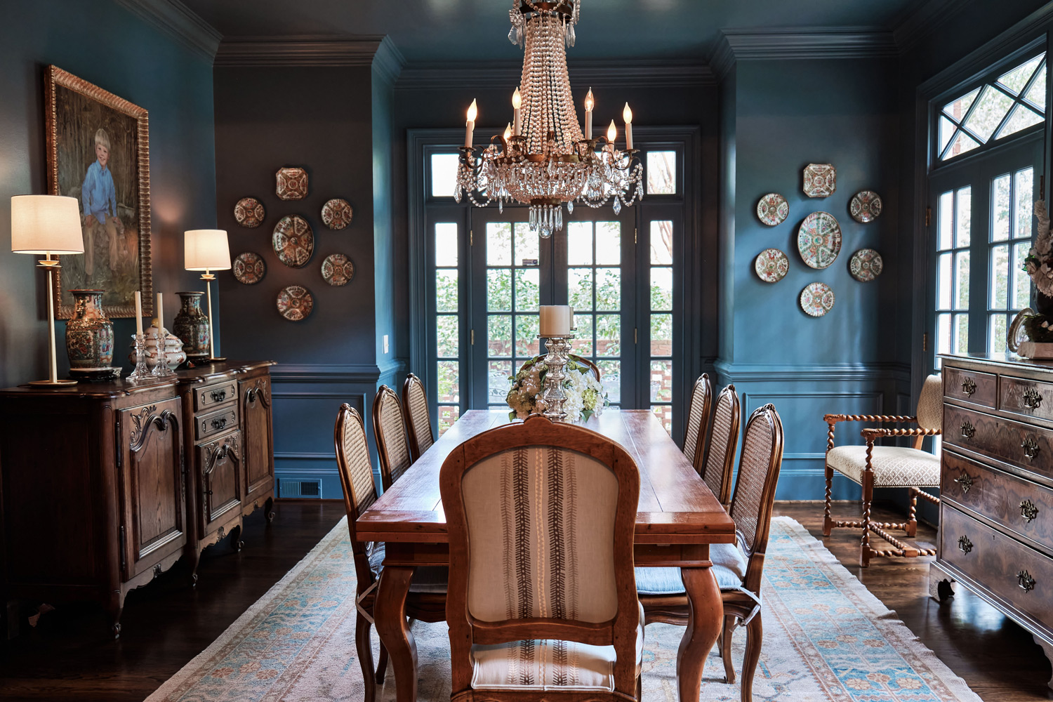 a dark blue dining room flows into the kitchen and provides a pop of color