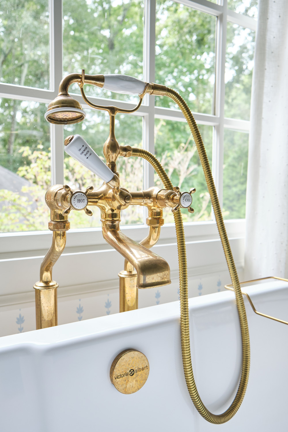 the traditional brass tub faucet with handheld shower and porcelain hot and cold valves