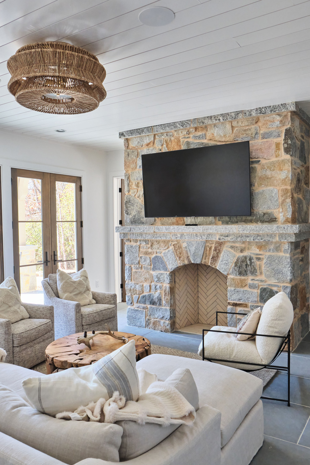 the downstairs living area with a stone fireplace as the centerpiece