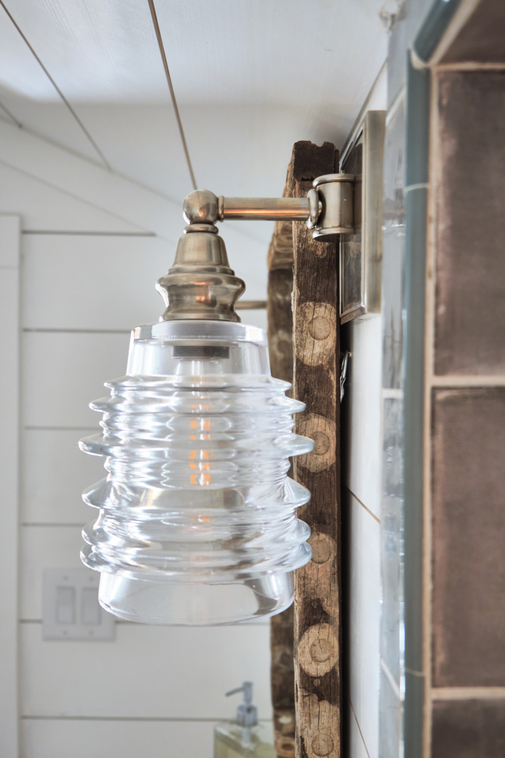 a brass and glass sconce in the loft bathroom