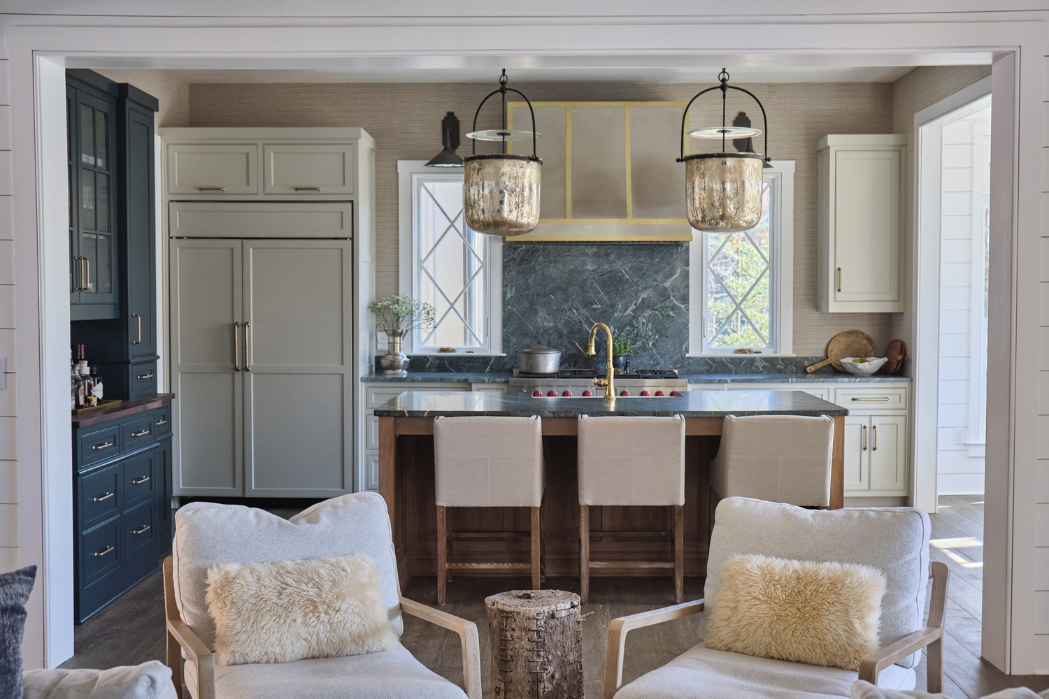 a view of the kitchen with navy blue and natural wood cabinetry and dark counters