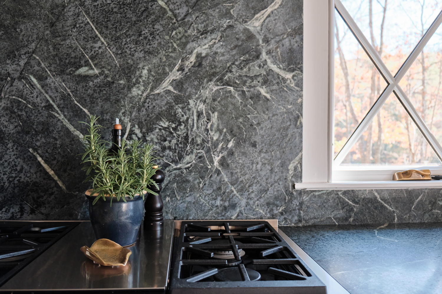 a detailed view of the dark stone backsplash by the stove