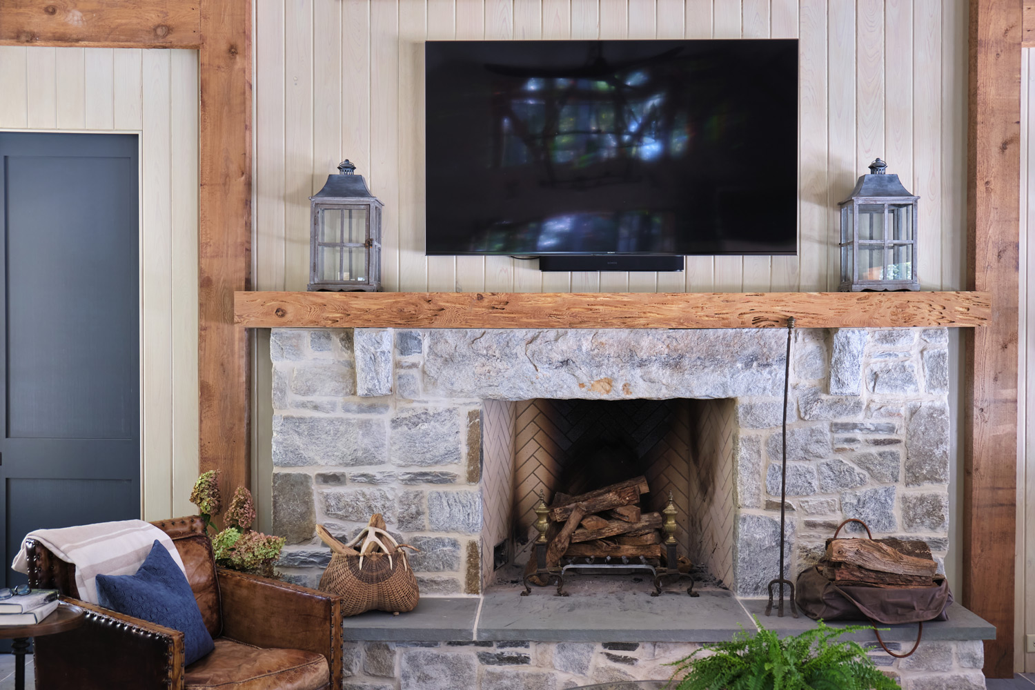 a closer view of the living area and stone fireplace in the pool house